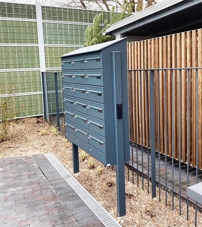 Fritstående digitalt postkasseanlæg med læser og digitale navneskilte til nemmere ejendomsadministration