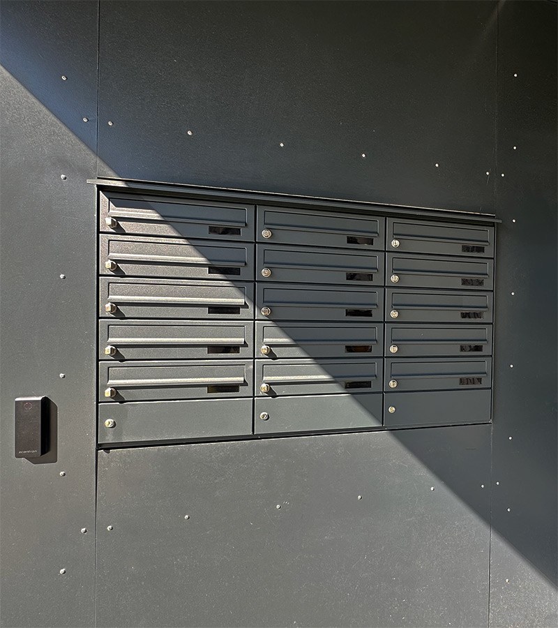 Planforsænket postkasseanlæg i mørke grå med adgangskontrol integreret i væg