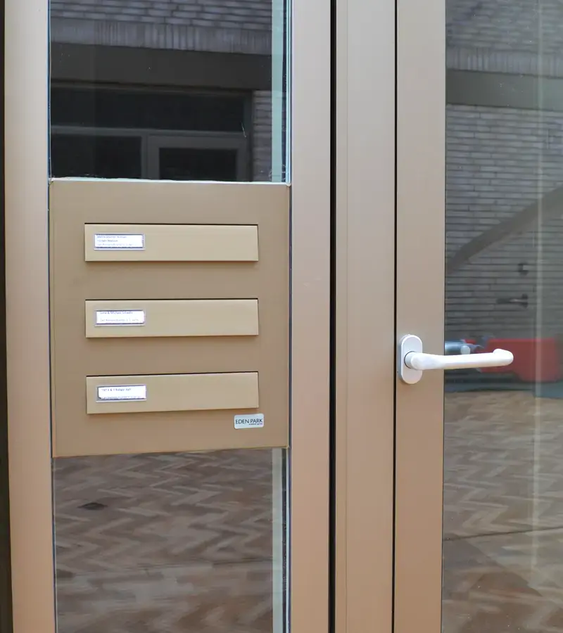 Skræddersyet postkasseanlæg som vinduesfyldning i indgangspartiet